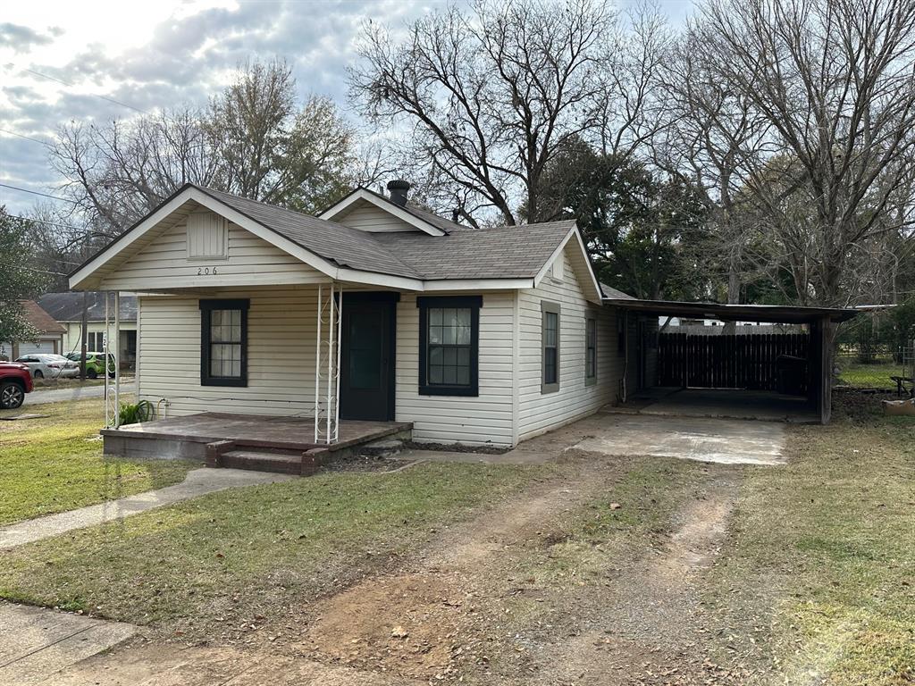 a view of a house with a yard and large tree