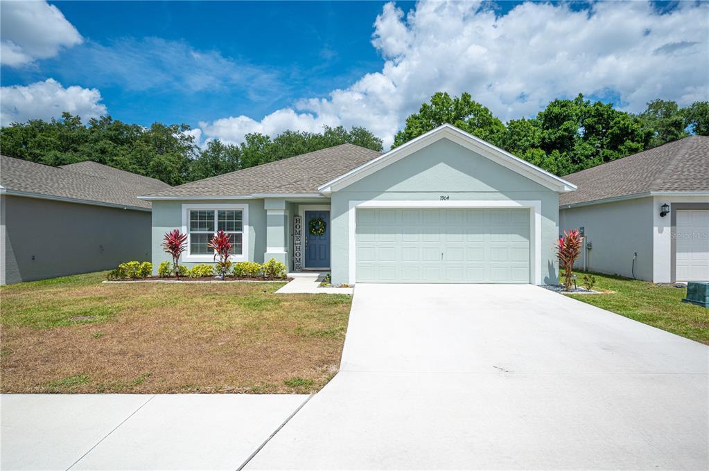 a front view of a house with a yard and garage