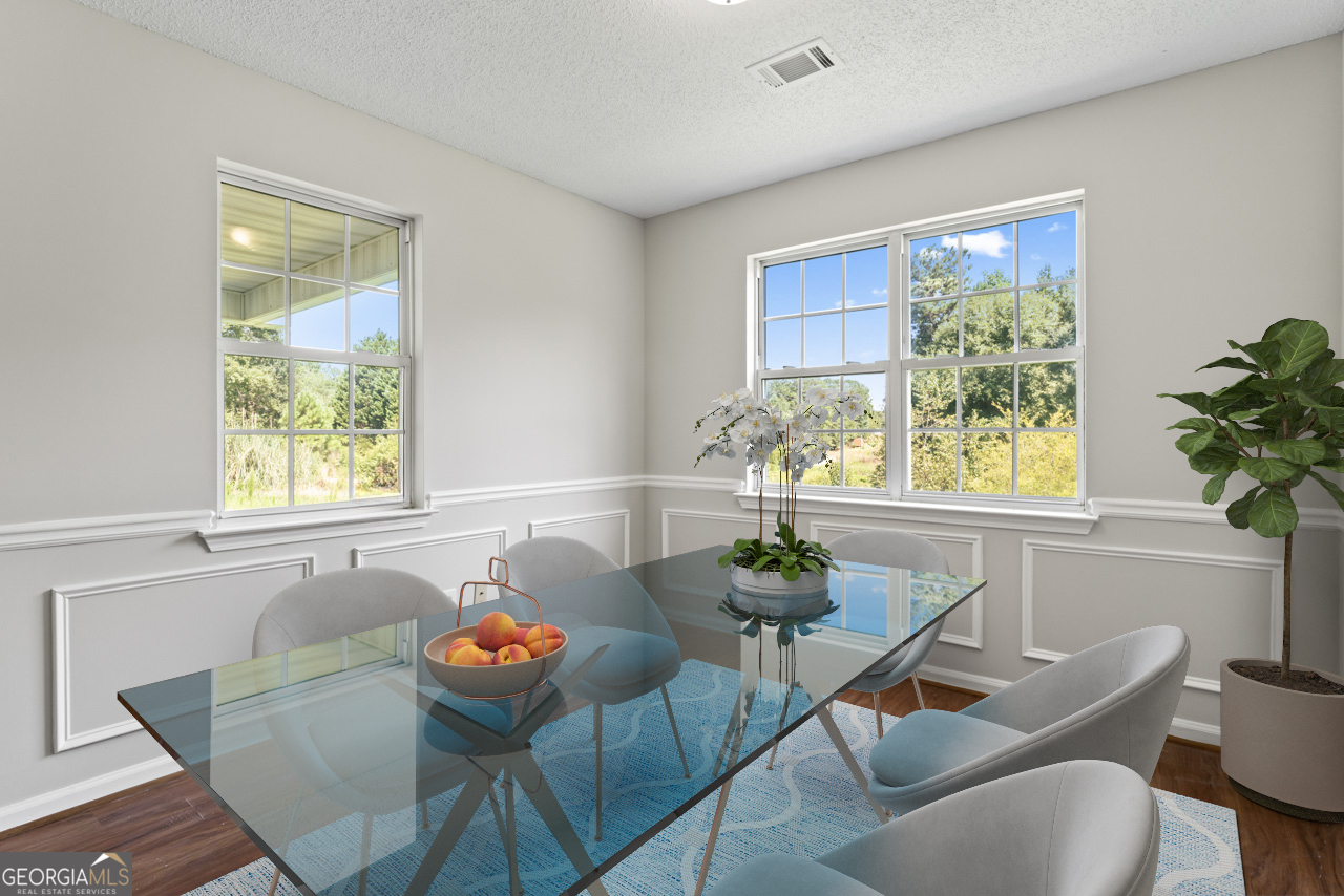 a dining room with furniture a potted plant and a rug