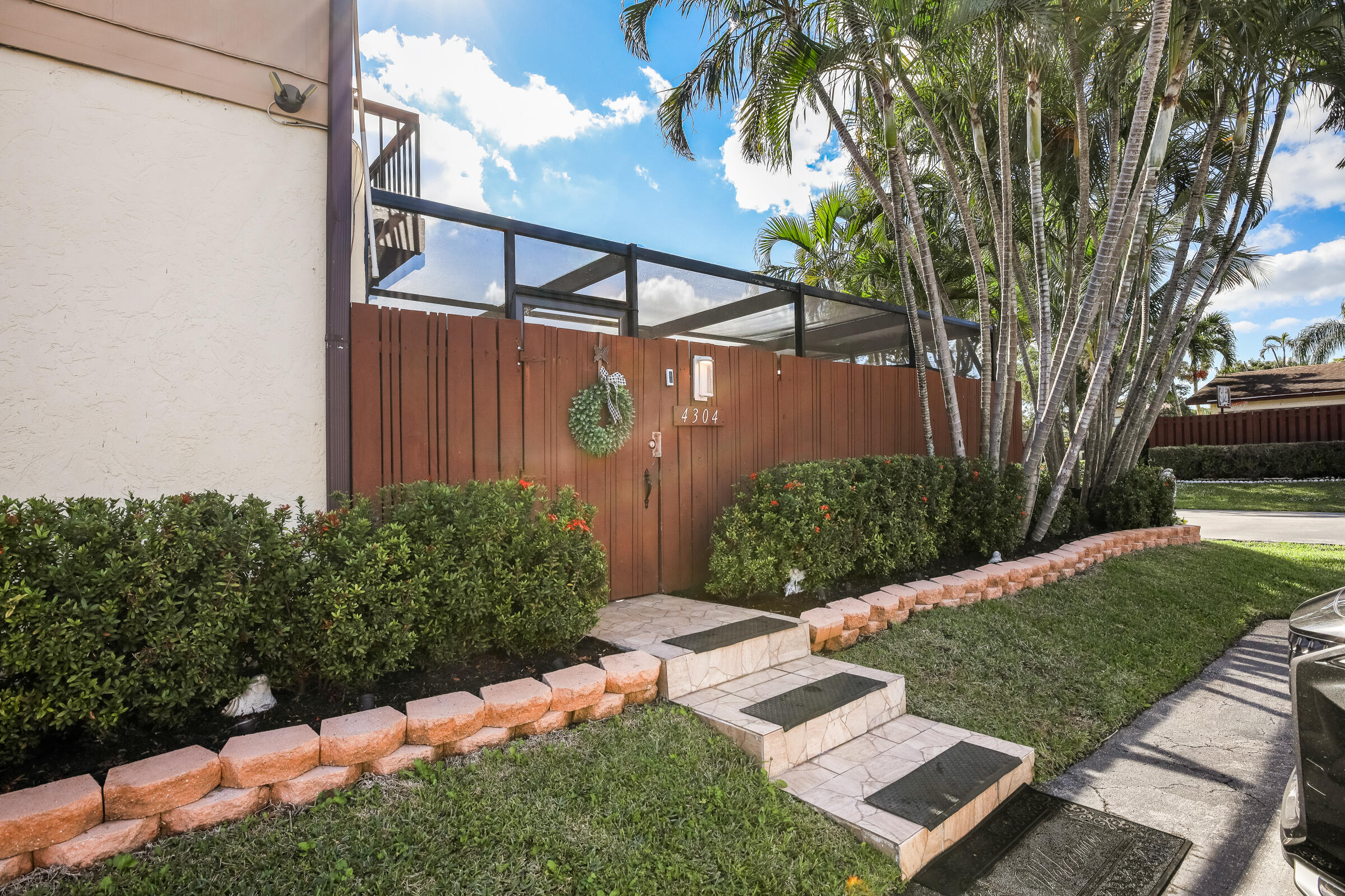 a view of a backyard with potted plants and large tree