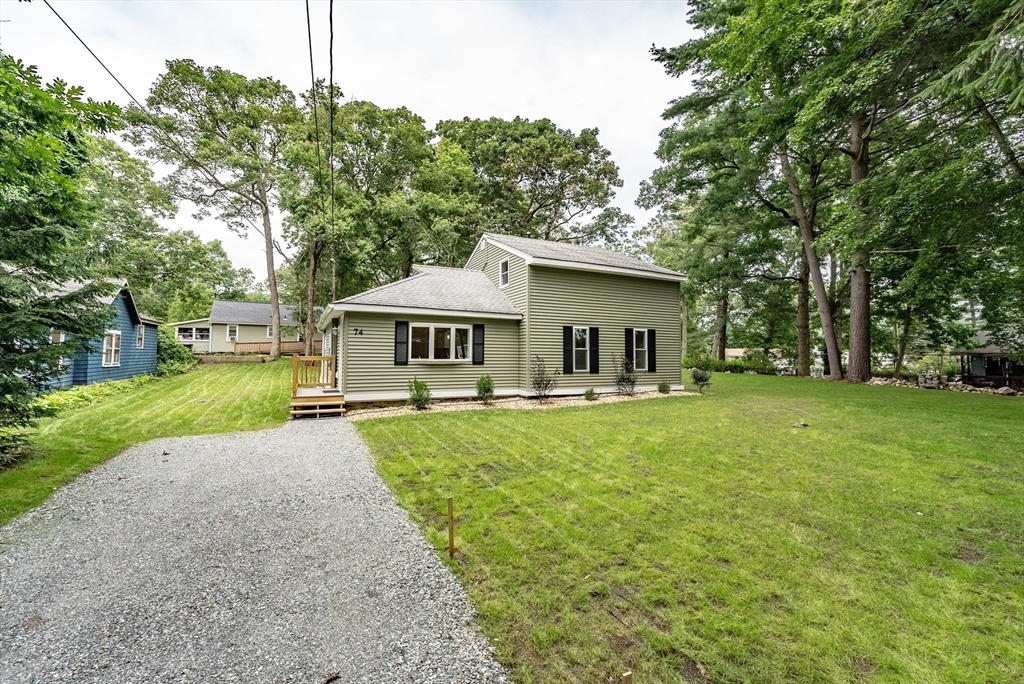 a front view of house with yard and trees