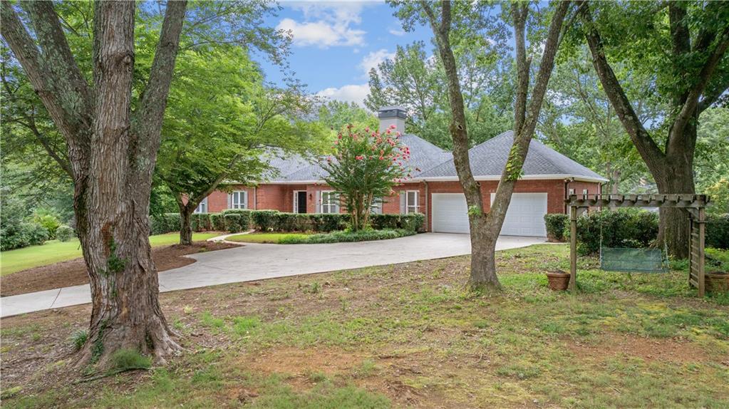 a front view of a house with a yard and tree