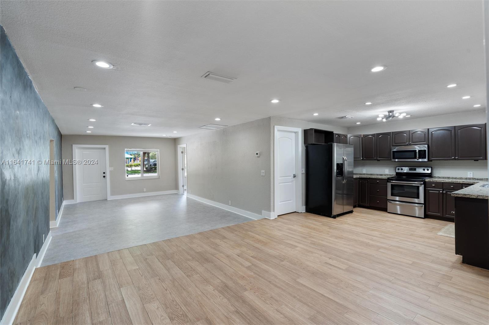 a view of kitchen with kitchen island microwave and refrigerator