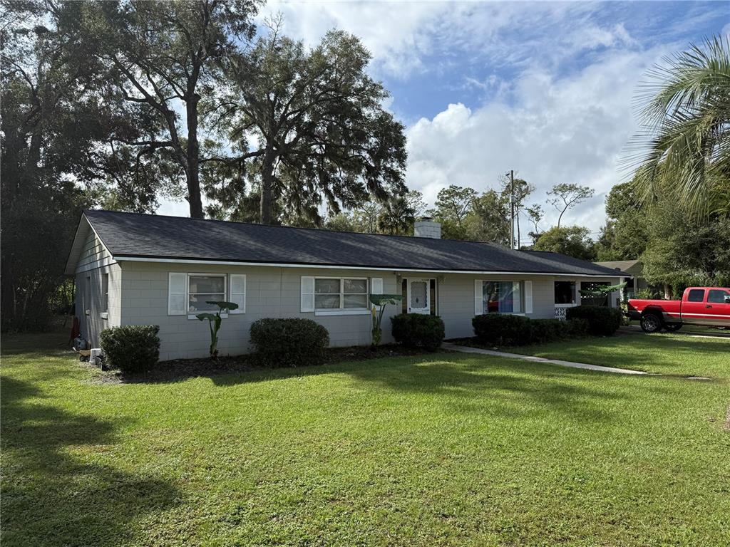 a front view of a house with a garden and trees