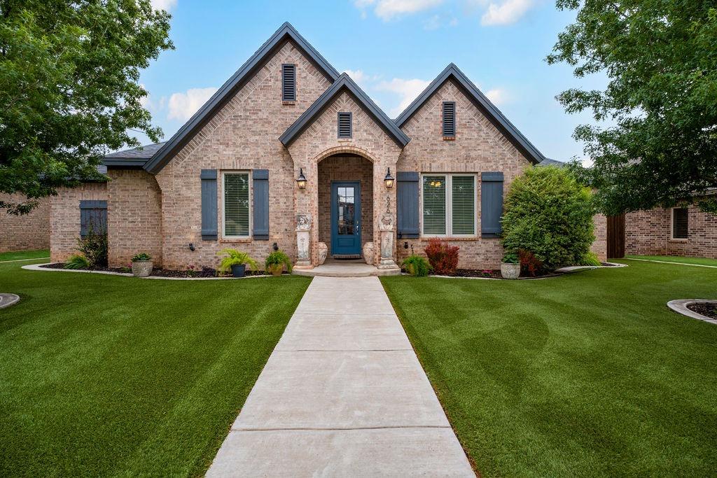 a front view of a house with a yard and potted plants