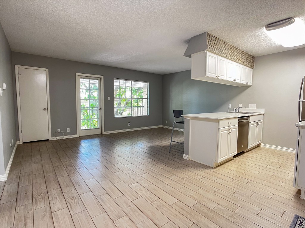 a view of a kitchen with wooden floor and a sink