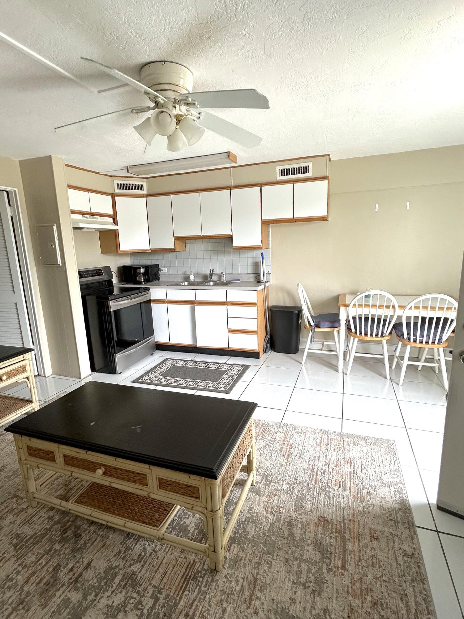 a kitchen with stainless steel appliances a stove a sink a oven a dining table and chairs