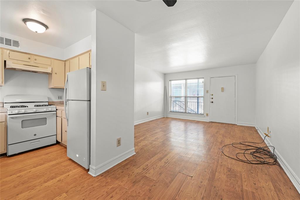 a view of a kitchen with wooden floor and electronic appliances