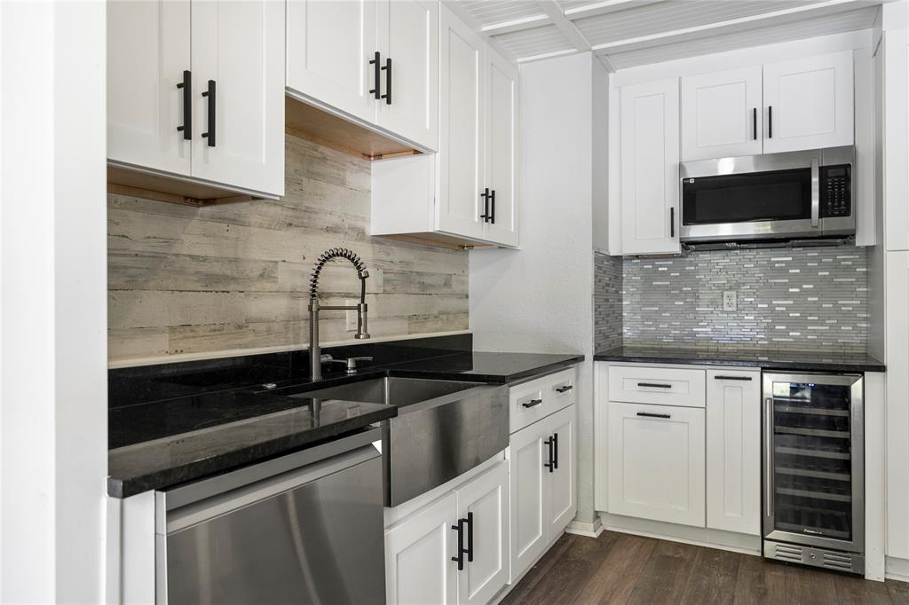 a kitchen with granite countertop white cabinets and stainless steel appliances