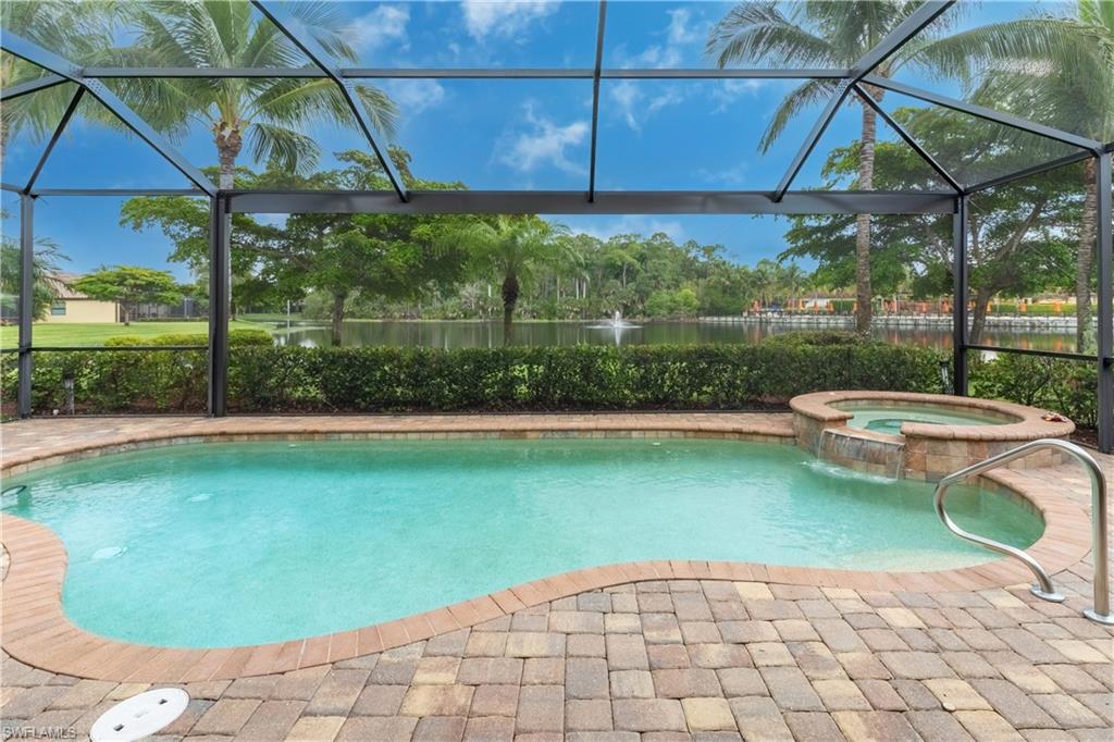 View of swimming pool with a lanai and an in ground hot tub