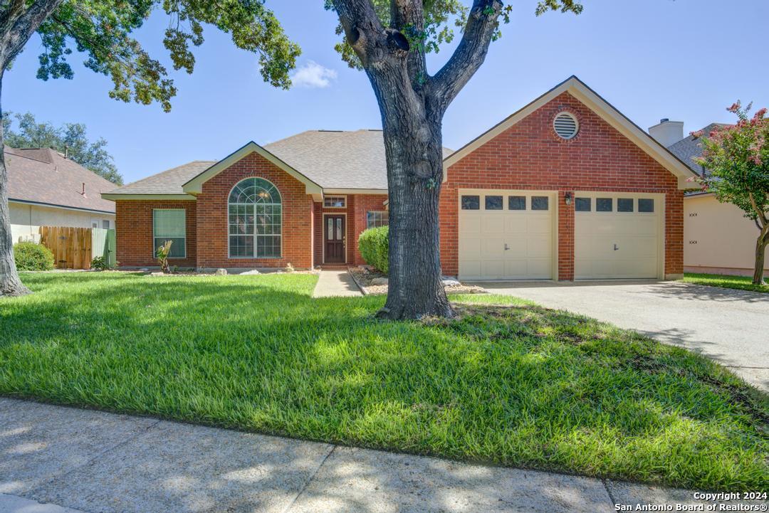 a front view of a house with yard and green space