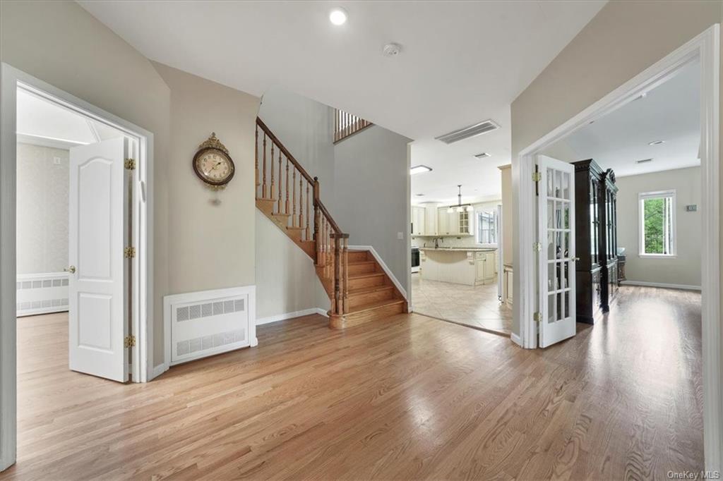 a view of a hallway with wooden floor windows and a living room