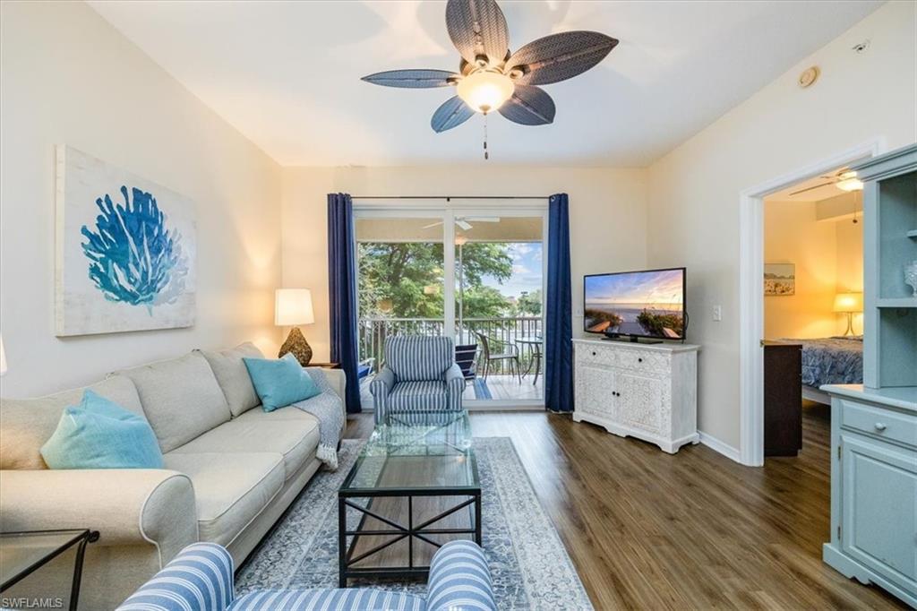 a living room with furniture flat screen tv and a large window