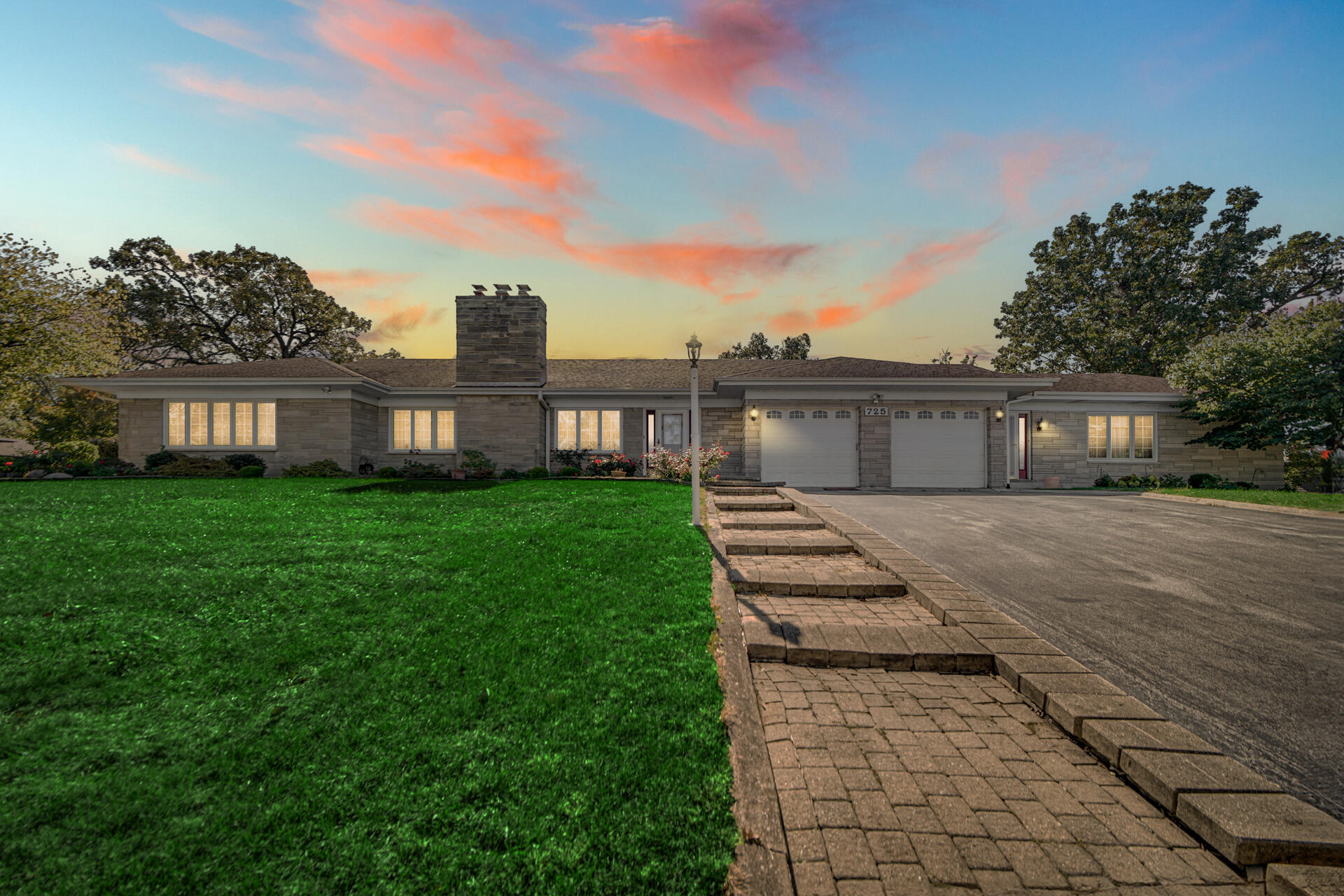 a front view of a house with a yard and trees