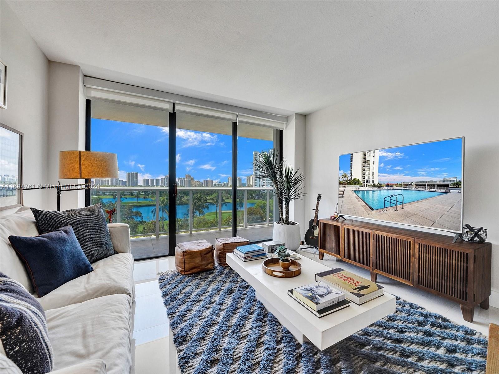 a living room with furniture and a floor to ceiling window