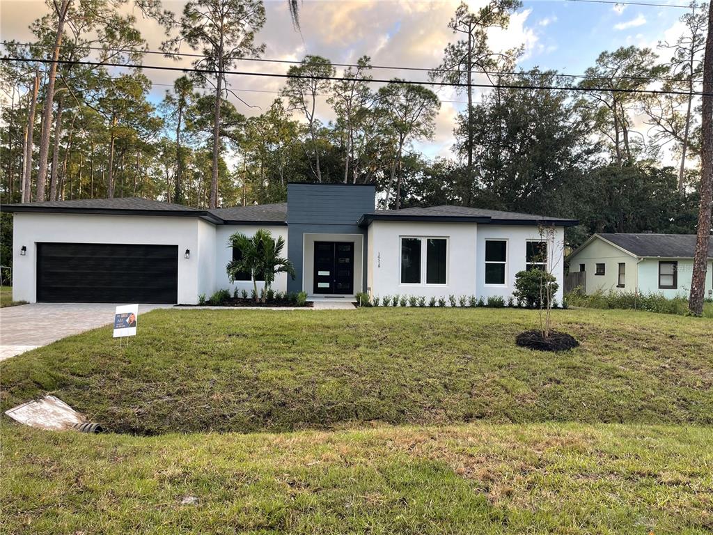 a front view of a house with a garden and trees