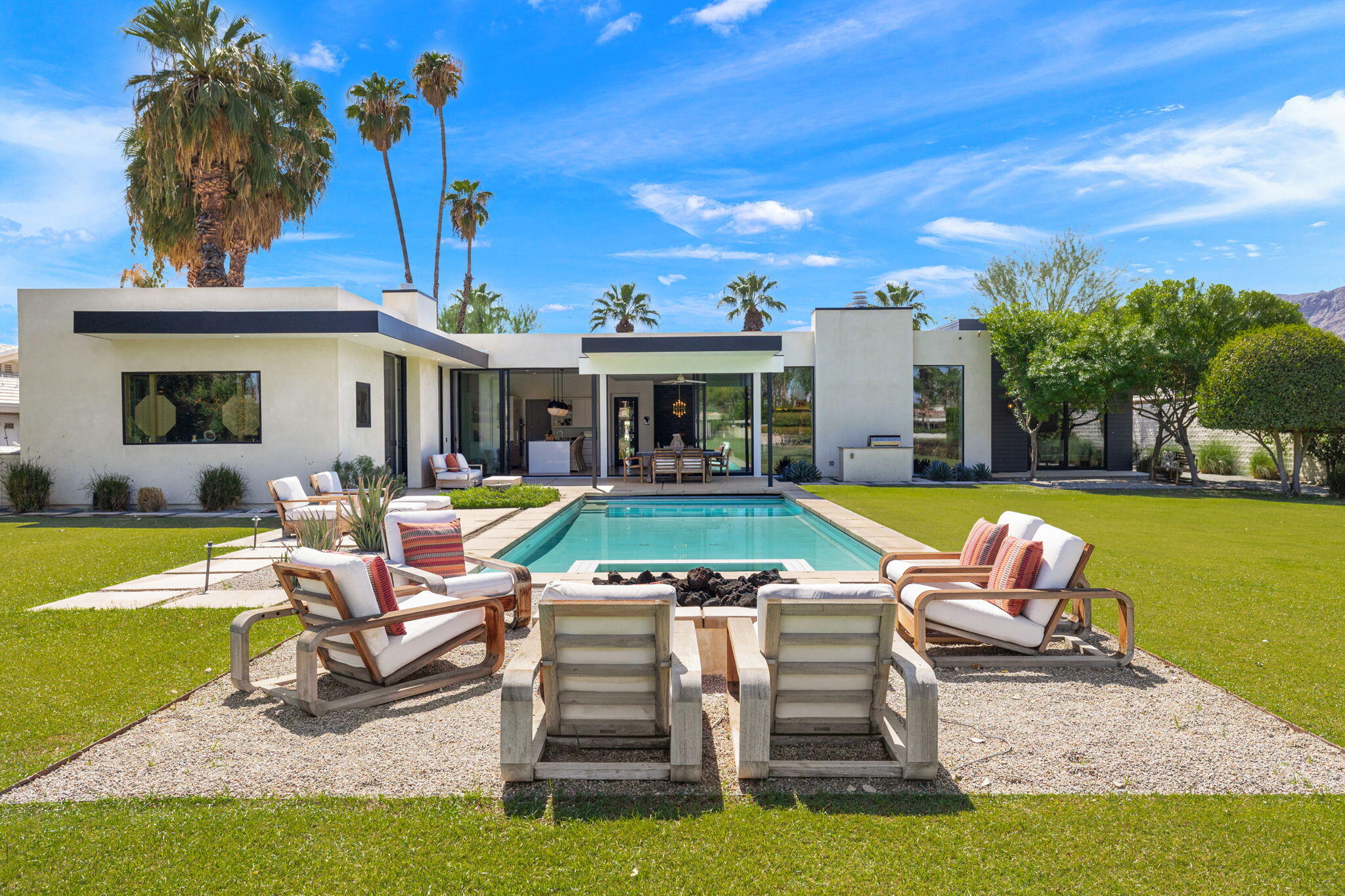 a view of a house with swimming pool and sitting area