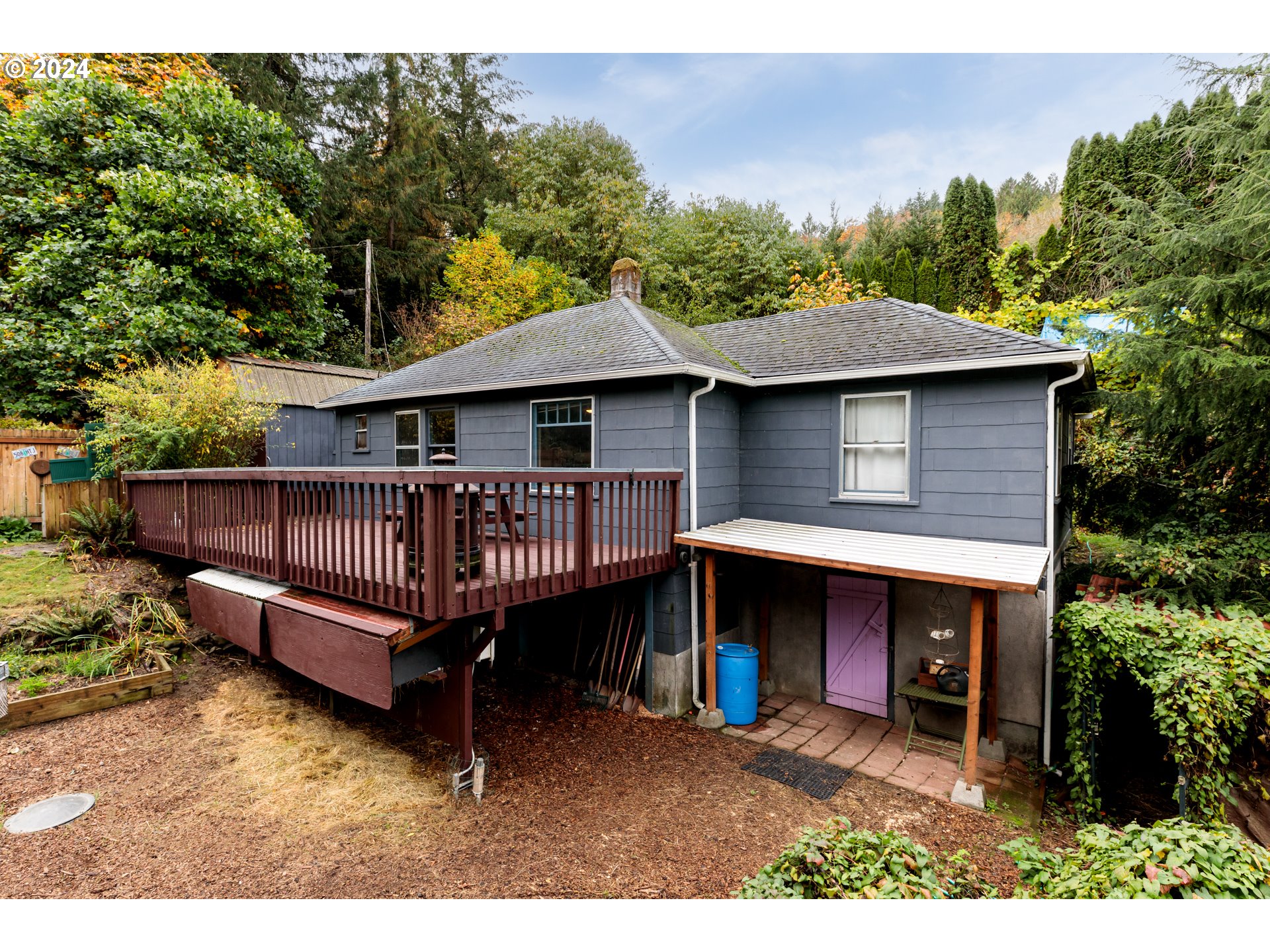 a small house with a wooden deck and furniture