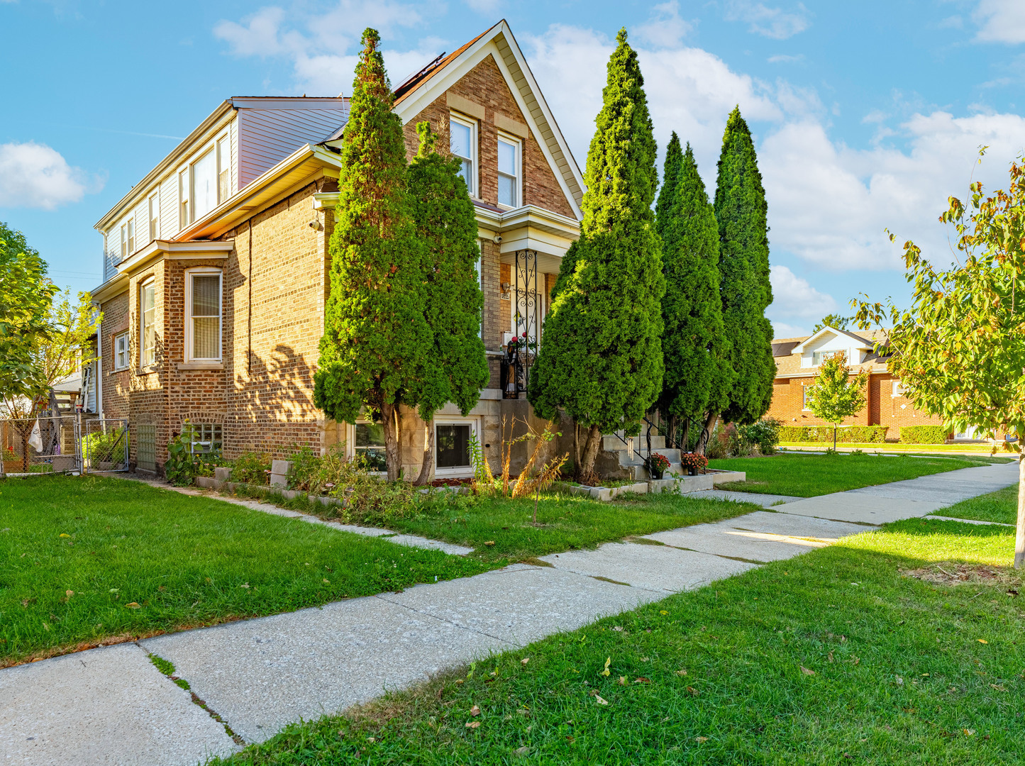 a view of a white house with a big yard and potted plants