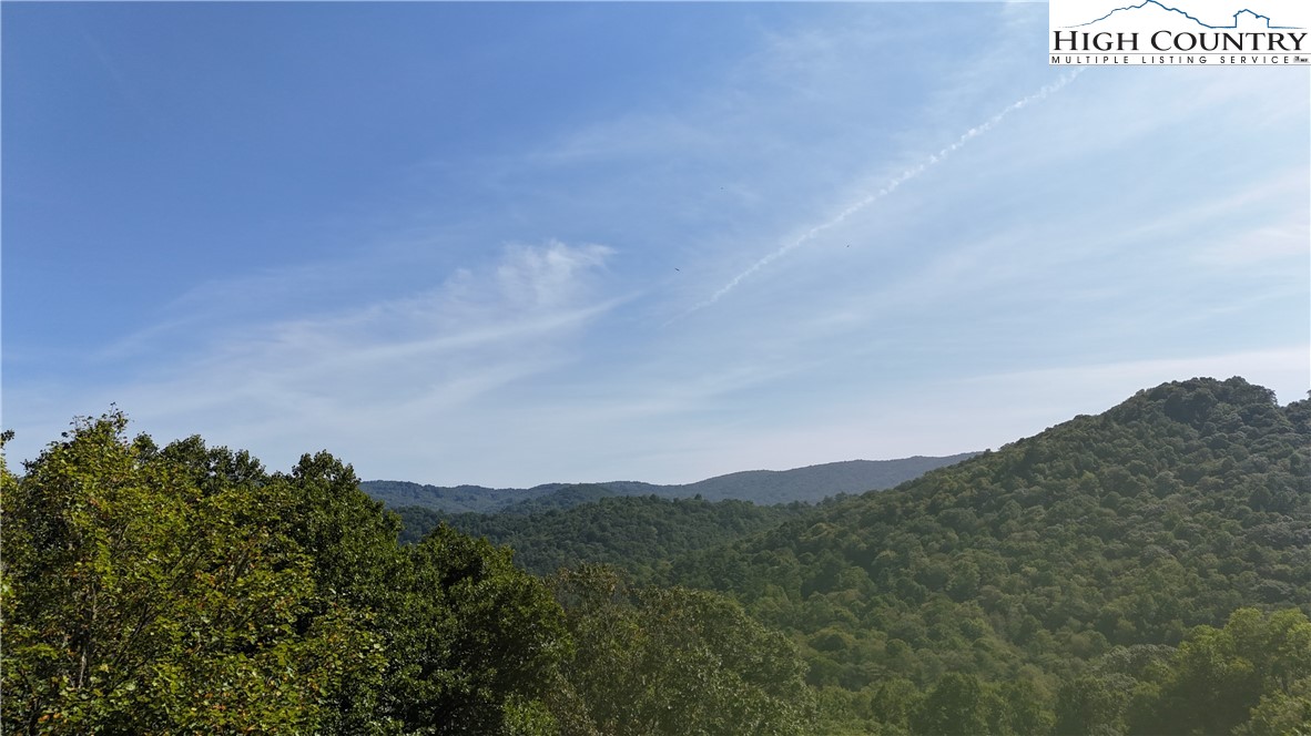 a view of a dry field with mountains in the background