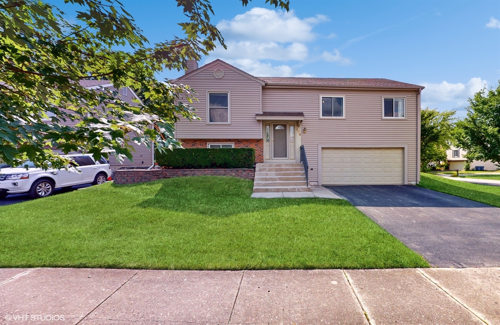 a front view of a house with a garden and yard