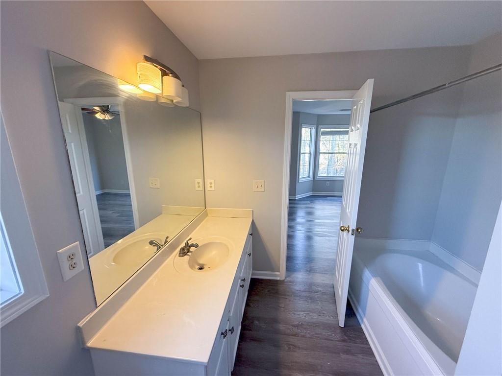 a bathroom with a tub sink and mirror