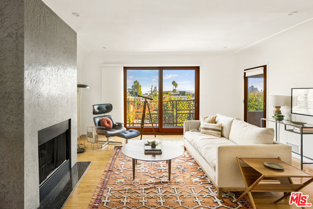 a living room with furniture large window and a fireplace