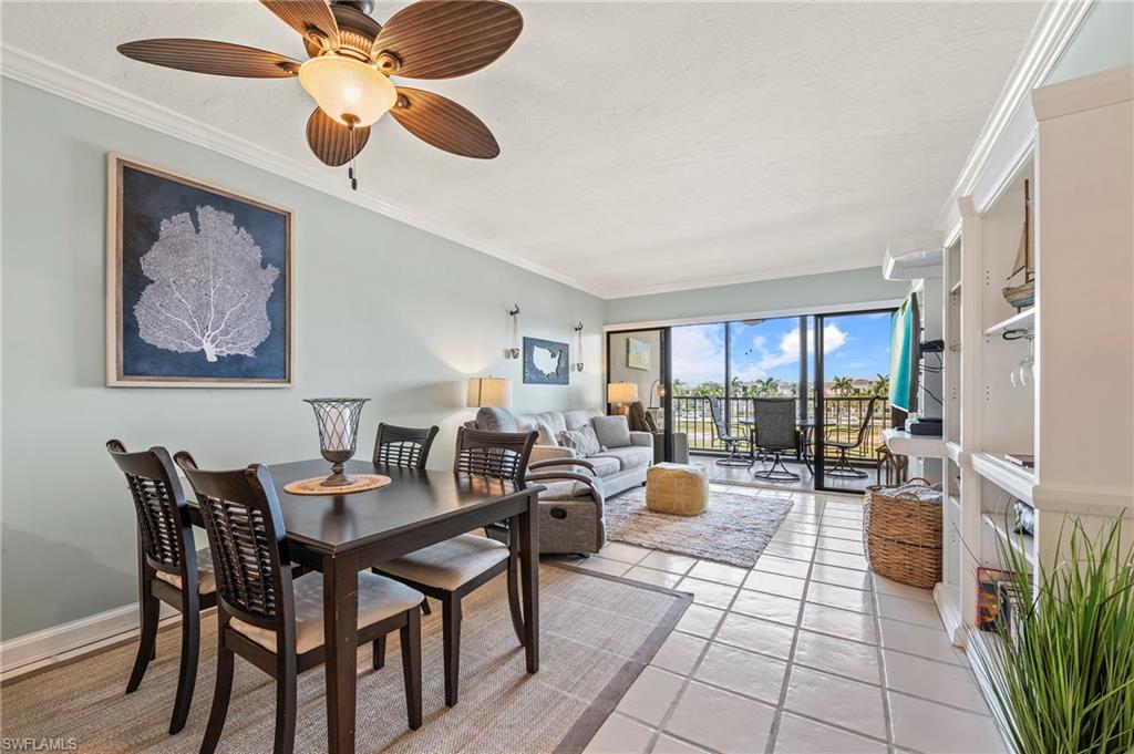 Dining room featuring crown molding, light tile patterned floors, and ceiling fan