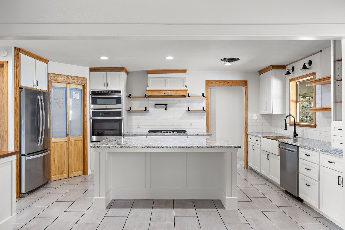 a kitchen with stainless steel appliances a refrigerator sink and cabinets