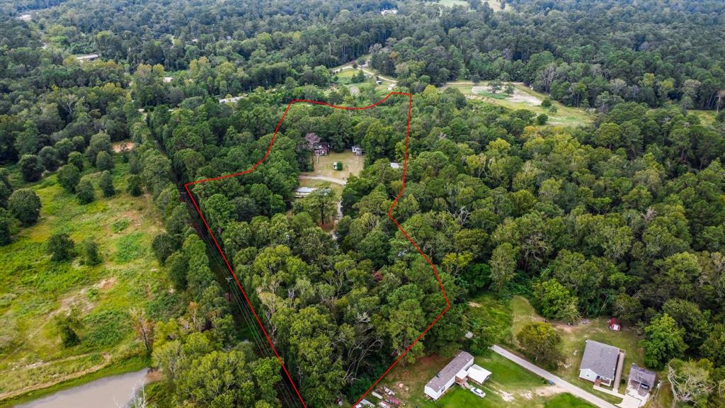 an aerial view of residential houses with outdoor space and trees