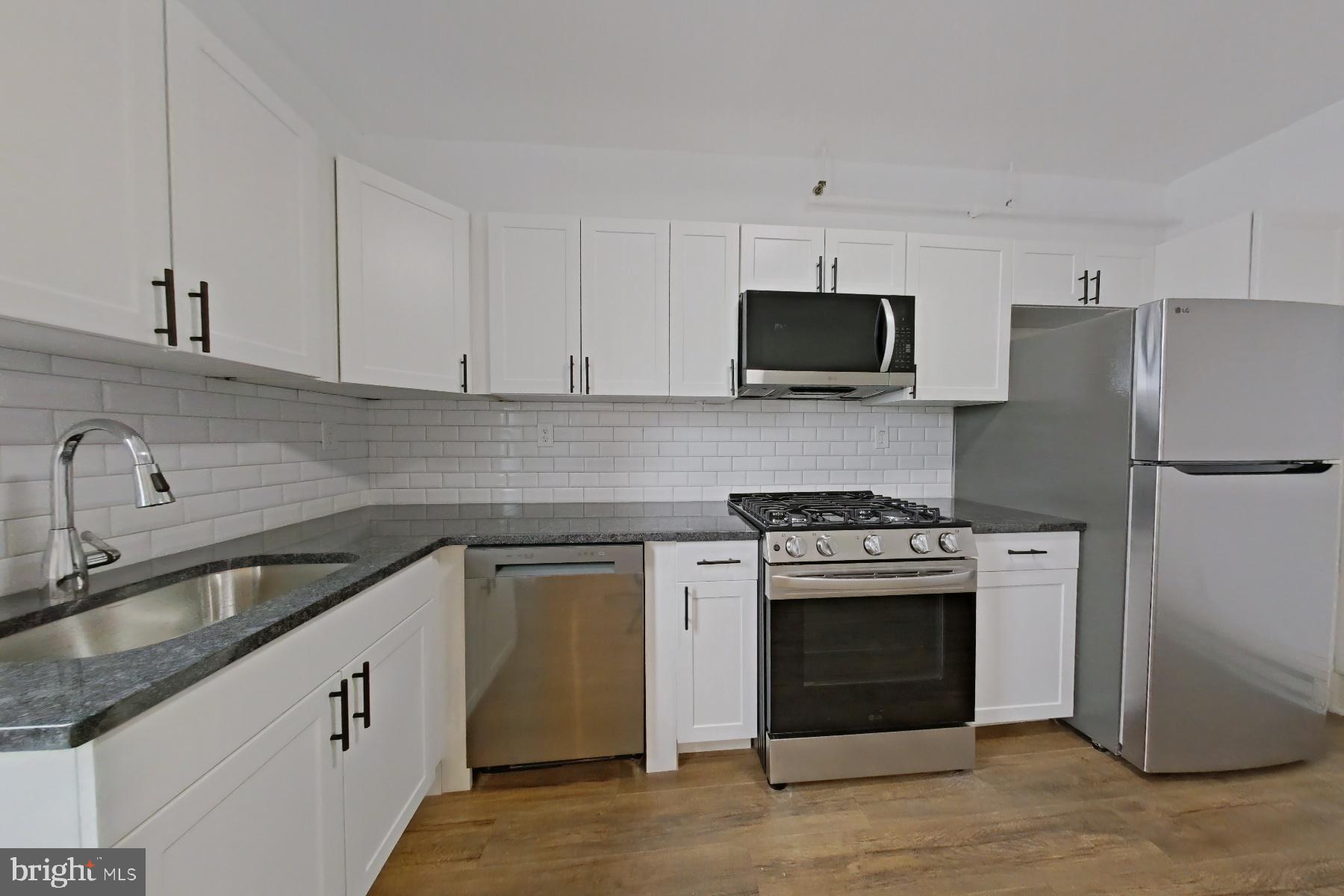 a kitchen with white cabinets and stainless steel appliances