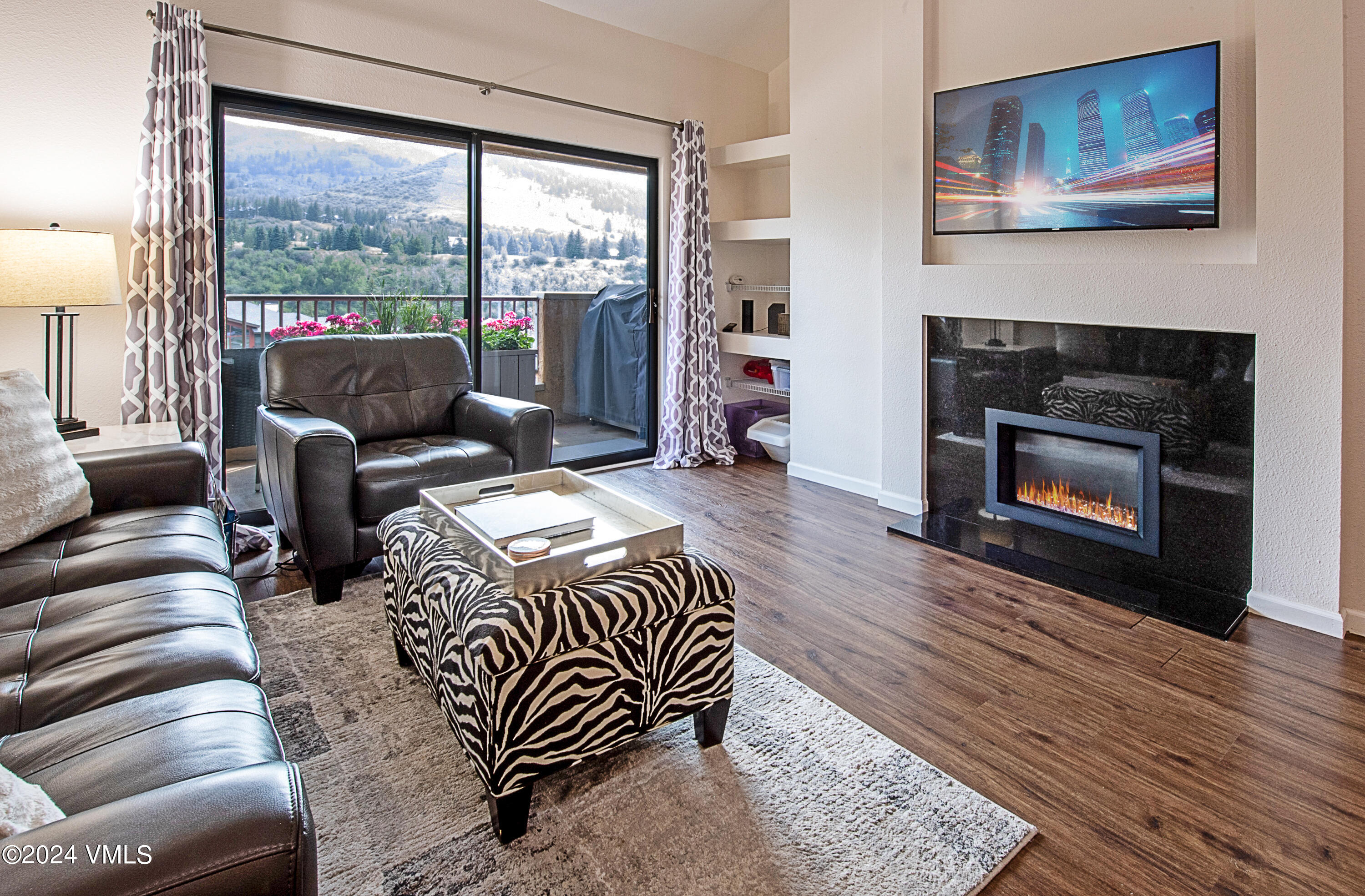 a living room with furniture large window and a fireplace