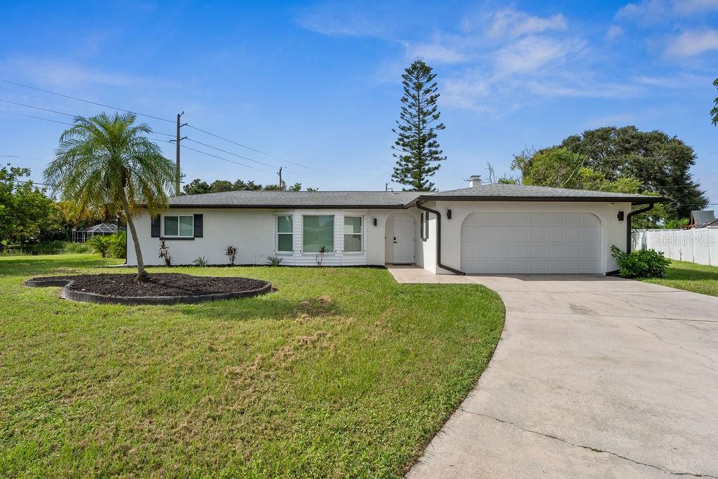 a view of a house with a backyard and a tree