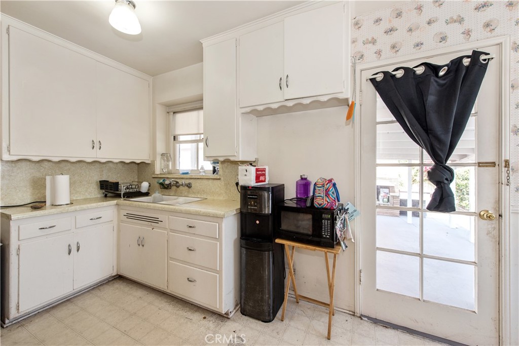 a kitchen with a refrigerator and white cabinets