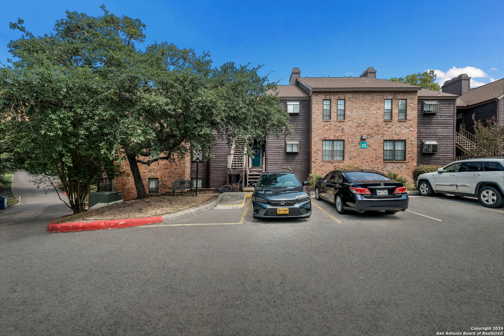 a car parked in front of a house with cars parked on road