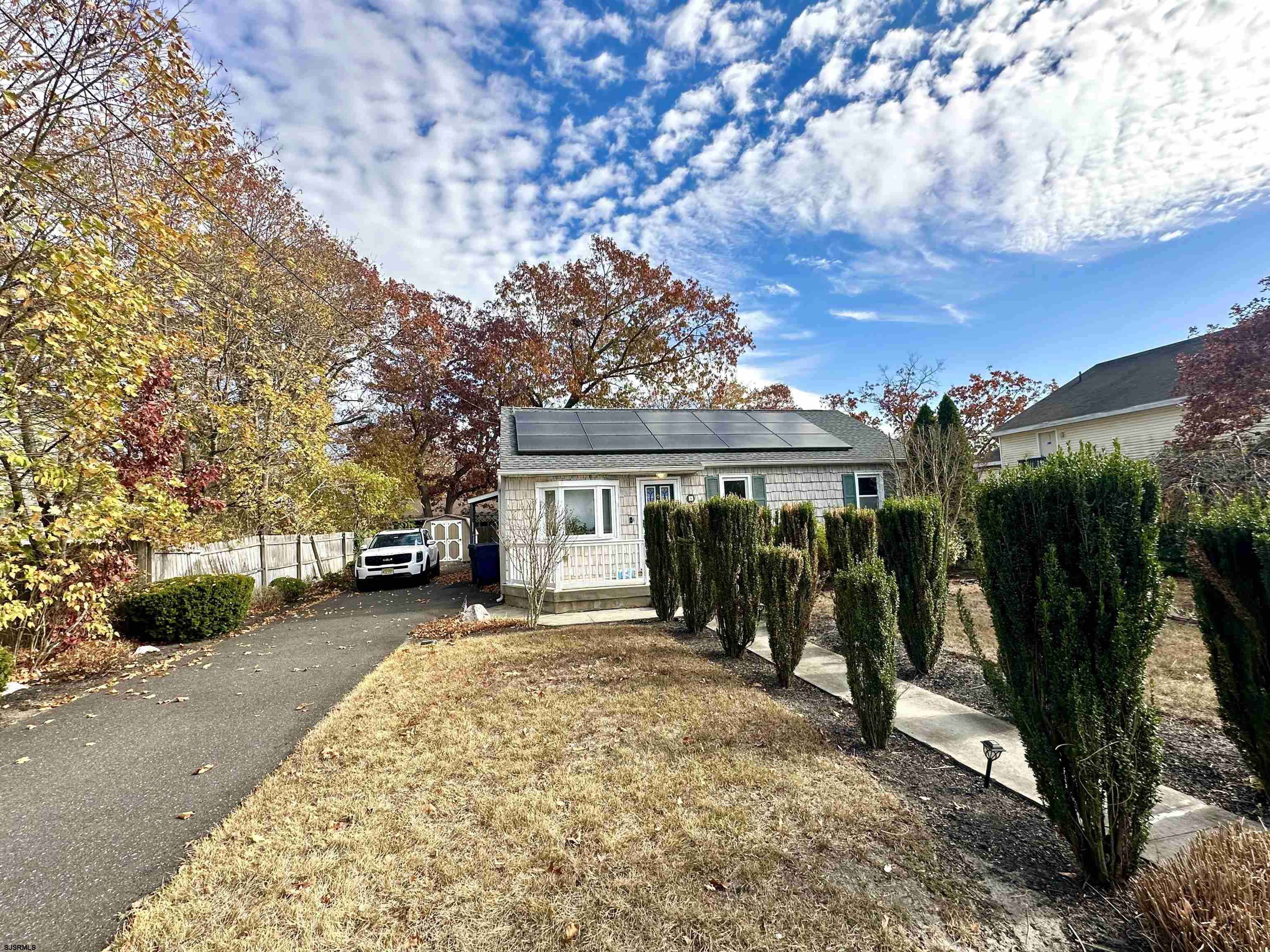 front view of a house with a yard and trees