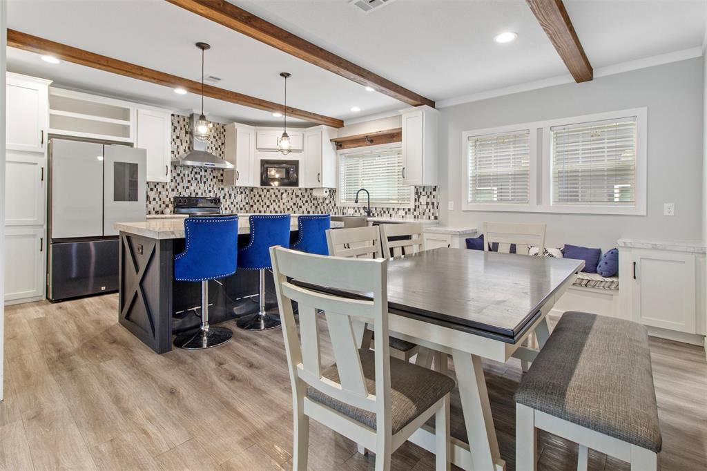 a dining table with chairs and kitchen view