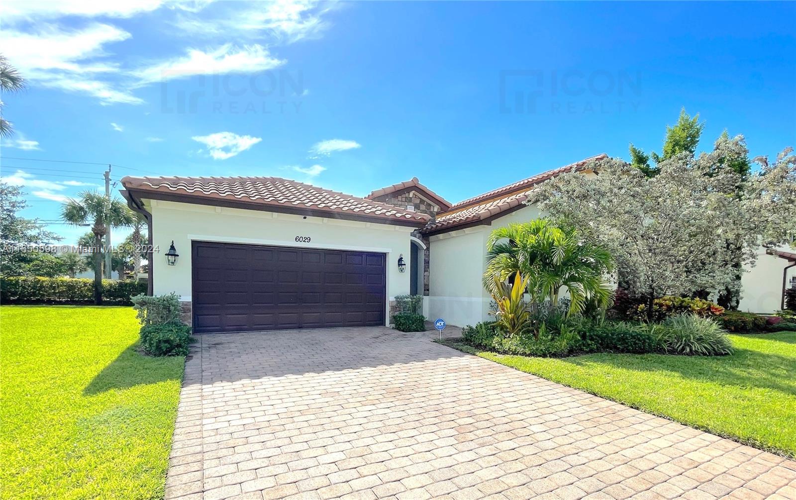 a front view of a house with a yard and garage