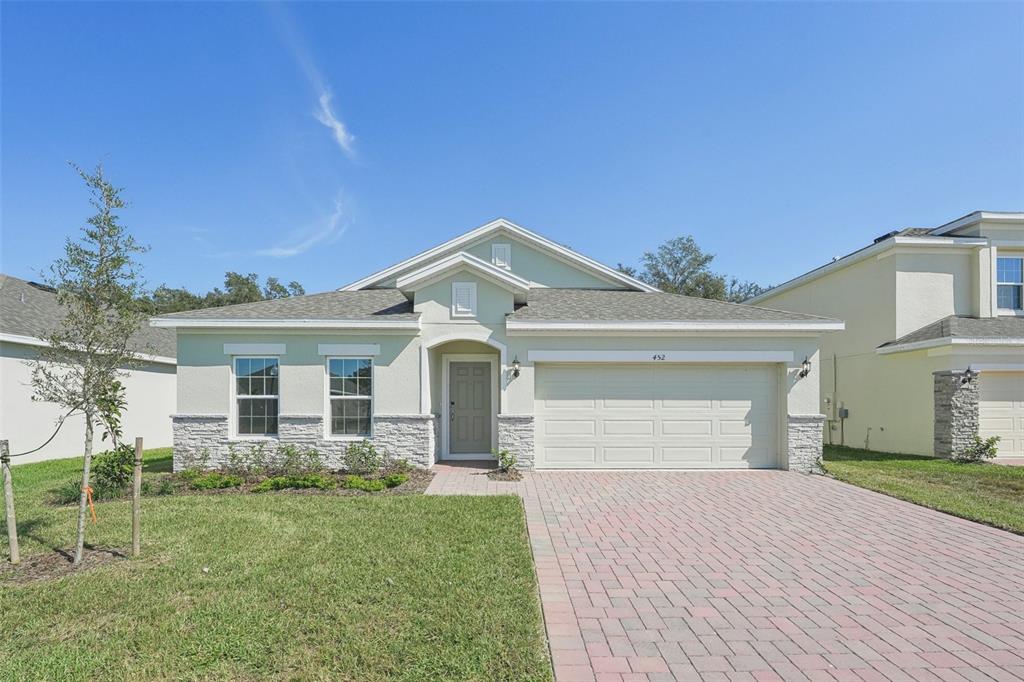 a front view of a house with a yard and garage