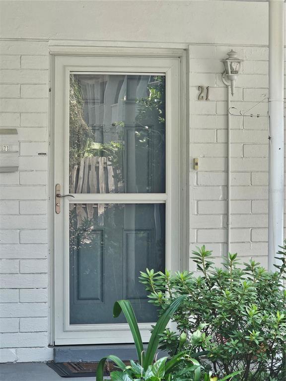 a glass door with a potted plant on the side door