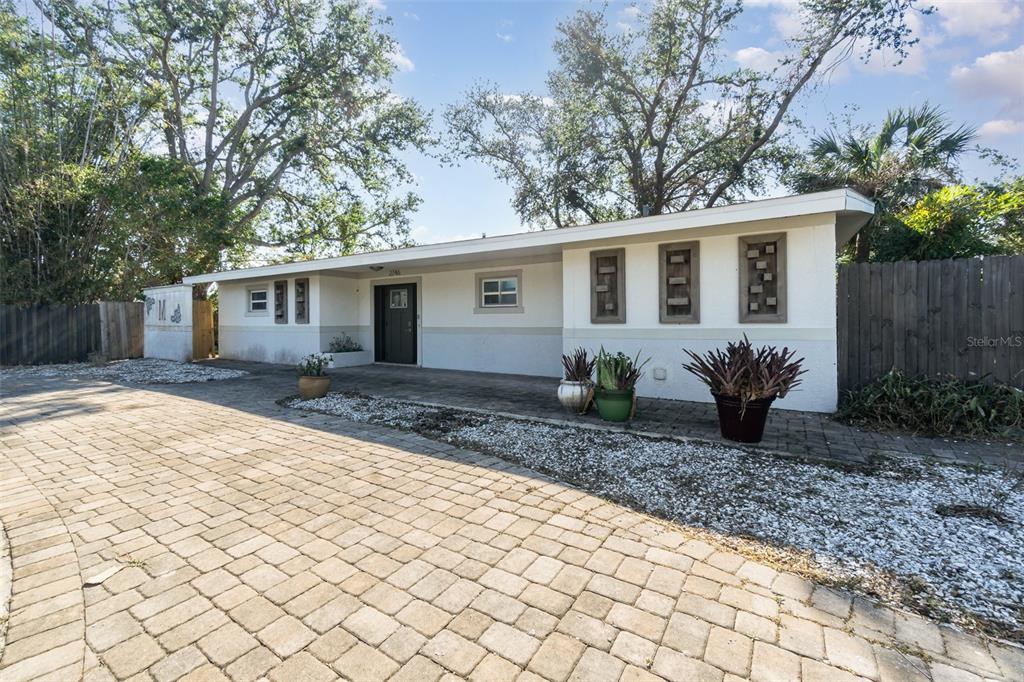 a view of house with backyard and sitting area