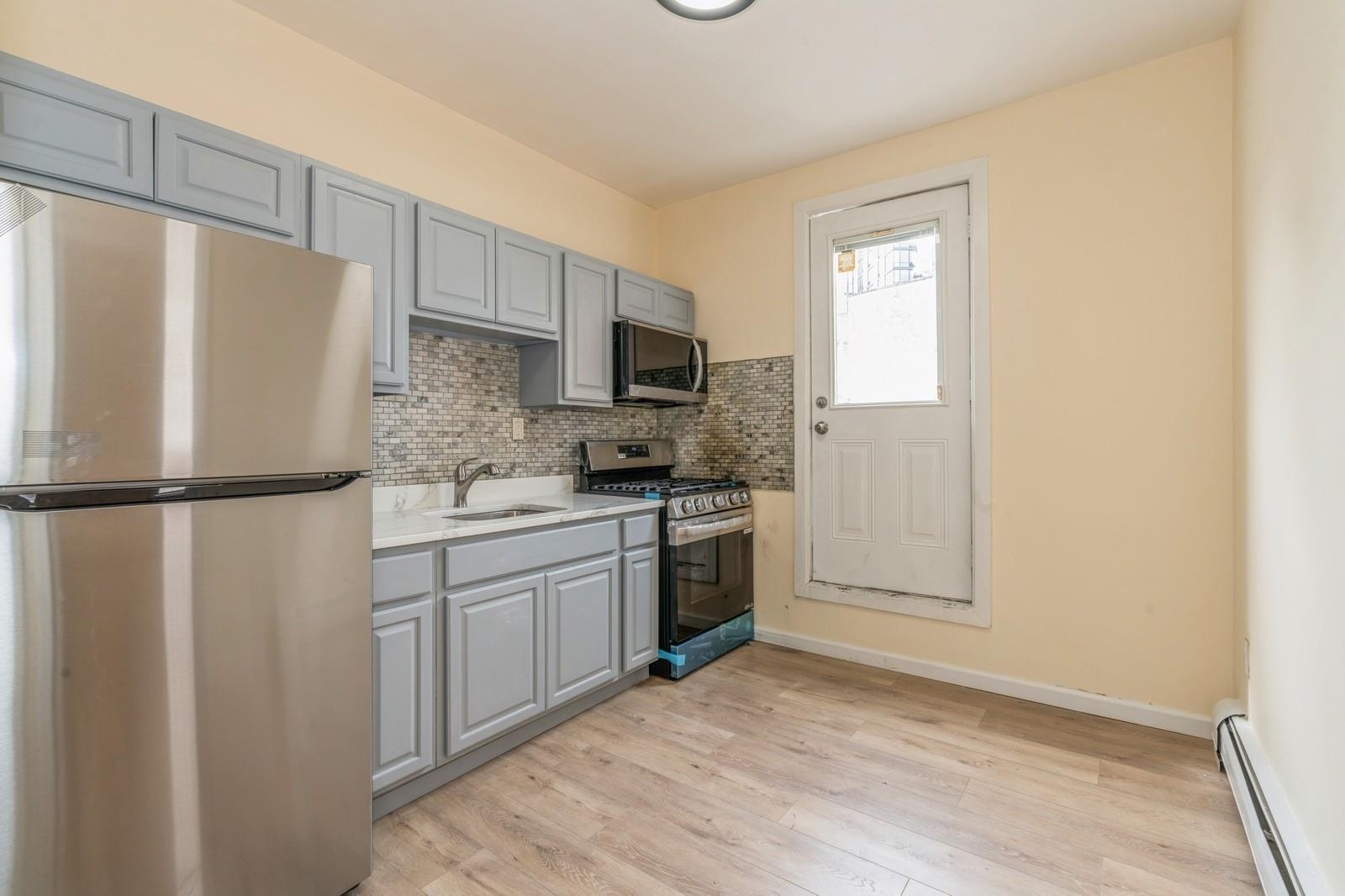 a kitchen with stainless steel appliances a refrigerator sink and microwave