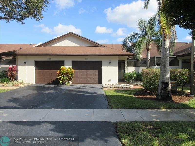 a front view of a house with a yard and a garage