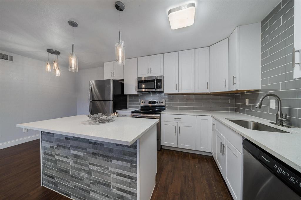 a kitchen with a sink a stove a microwave and cabinets