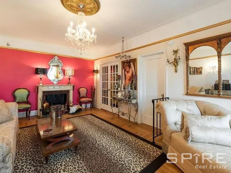 a living room with furniture a fireplace and a chandelier