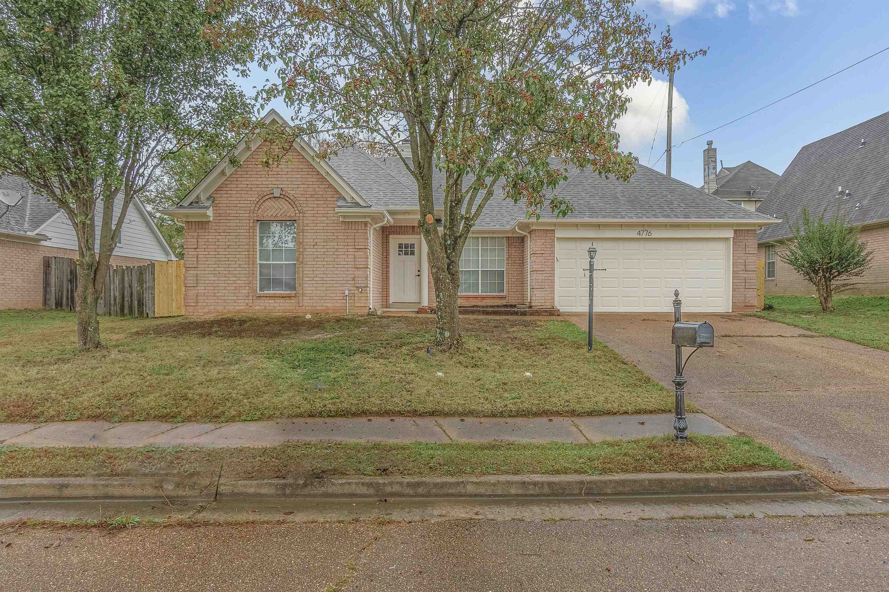 View of front of property with a garage and a front lawn