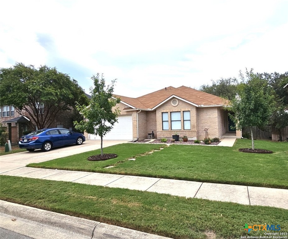 a view of a house with a big yard plants and large trees