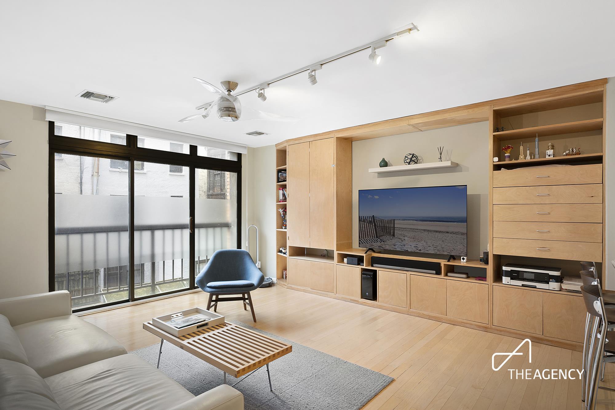 a living room with furniture tv and a window