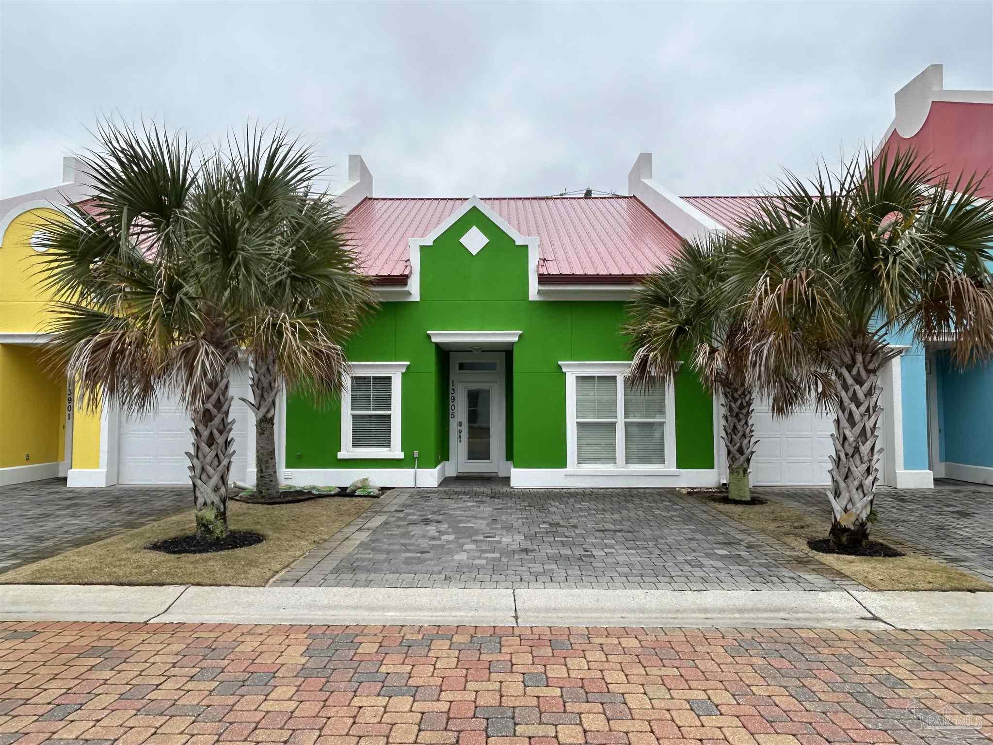 a front view of a house with a yard and palm tree