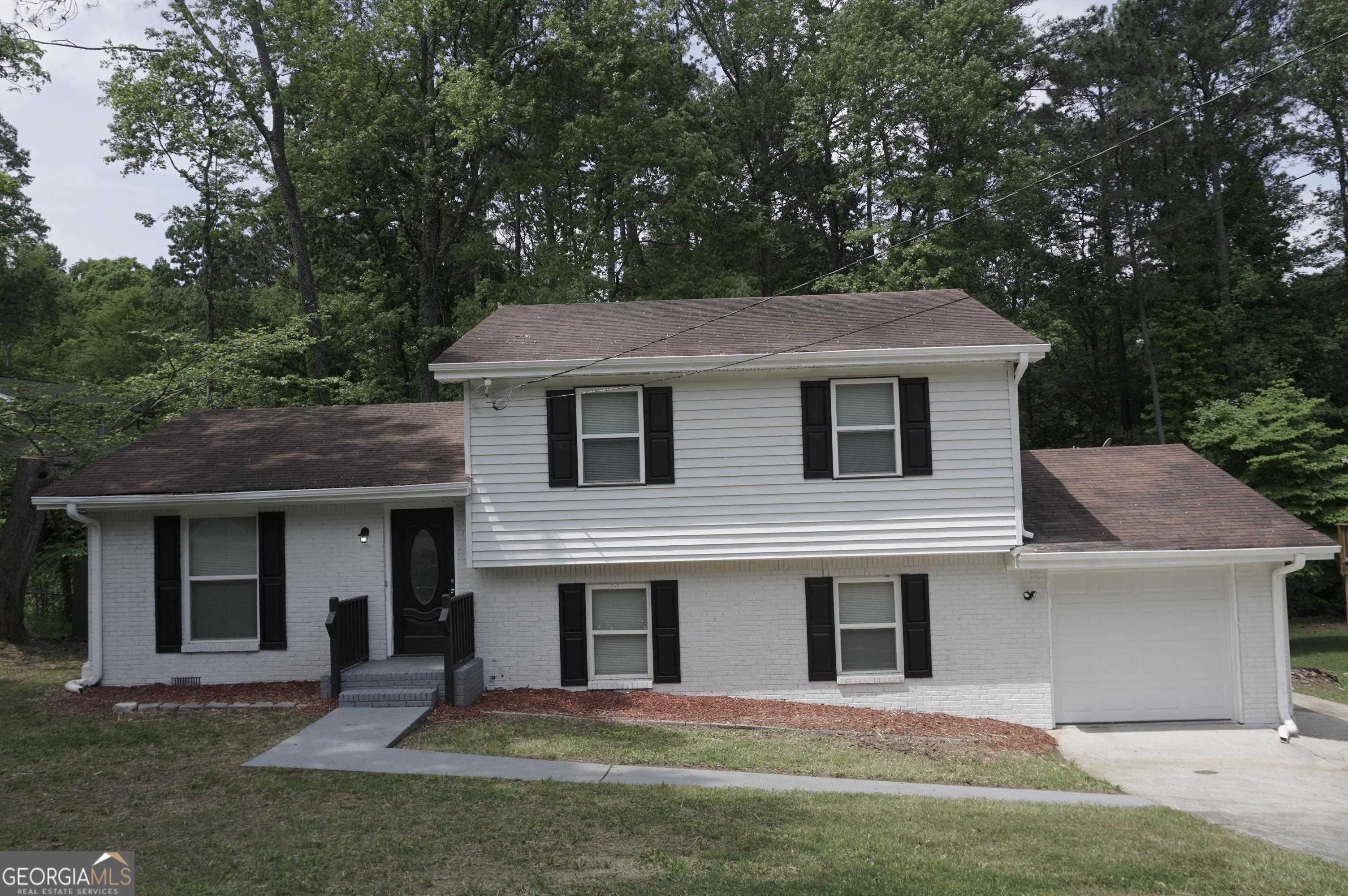 a front view of a house with a yard and trees